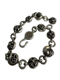 Performa Chrome Hearts sterling silver link bracelet with oxidized gothic cross and knot charms and hook closure.